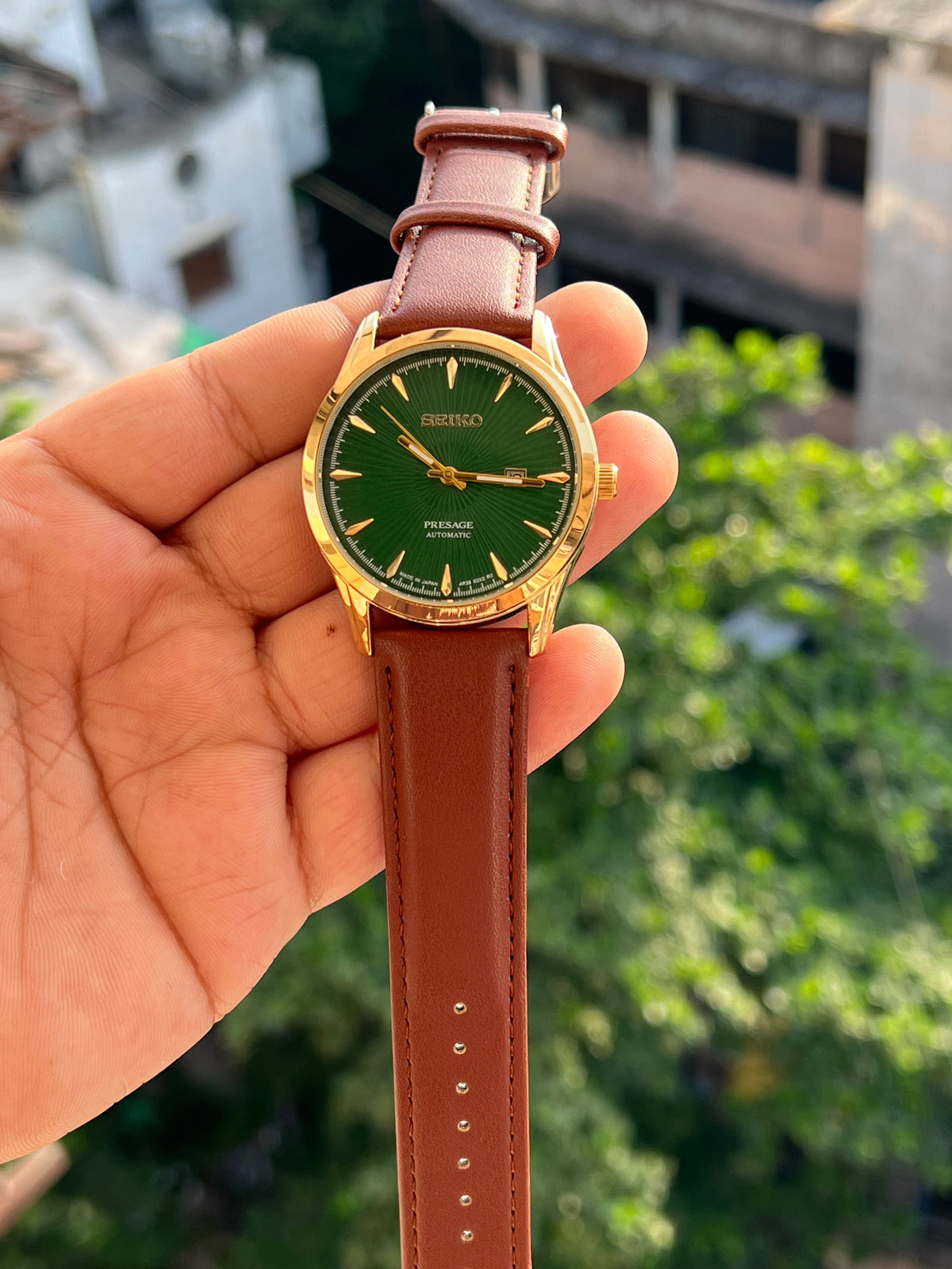 Green dial Seiko-inspired watch with gold-tone case and brown strap