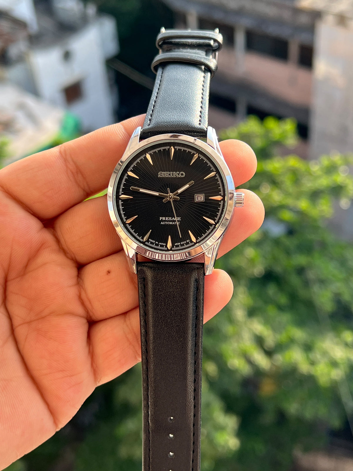 Black dial Seiko-inspired watch with silver-tone case and black strap
